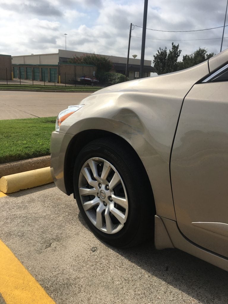 Hood with hail damage before repair