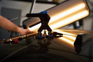 Technician performing mobile paintless dent repair